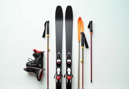 Set of skis, ski boots, and ski poles arranged neatly for display.