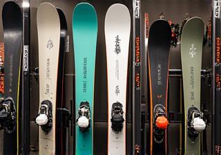 Variety of snowboards and skis displayed neatly on racks.